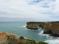 A gorge opens out into the sea, clear pale blue water gets darker toward the horizon.