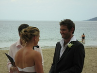 Hannah and Lee standing on the beach in front of the wedding celebrant.