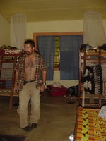 A dormitory room with two bunk beds and one single, Dave is standing in the middle of the floor.