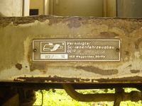 A metal plate bolted to a rusting railway carriage 'Vereinigter Schienenfahrzeugbau GDR', 'VEB Waggonbau G&oumlaut;rlitz' and stamped '853 / 90'.