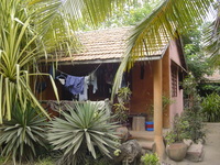 A terracotta-coloured building with washing hanging all over the verandah at the front.