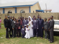 Wedding party standing in the car park in front of a church