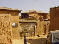 A crumbling house surrounded by mud walls