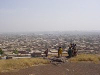 A crowd of children looking out over the city of Kano