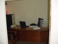 An office with a desk, chair, filing cabinet and not much else