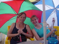 Mary and Tracey sitting with their umbrellas