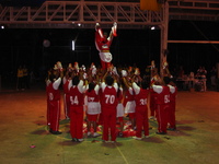 A group of people in red and white uniforms dancing.