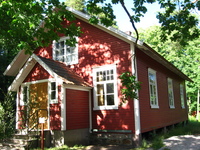 A small wooden building, painted red and white.