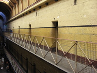 Tiers of cells line one side of an old prison wing.