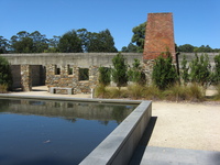 The shell of a building is seen across a reflecting pond.
