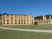 A large ruined stone building seen across a lawn.