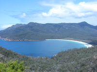 A beautiful bay surrounded by high, tree-covered headlands.