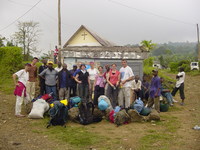 Large group in front of a roadside shack and church
