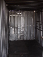 Inside of a metal hut, showing the many holes in the windward wall