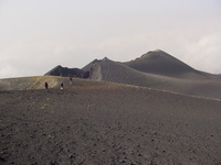 People walking across a landscape of ash and cinders