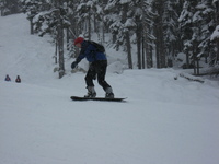 A beginner (me) snowboarding badly, snow falling between the camera and subject.