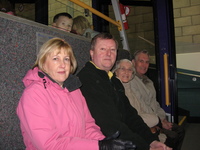 Four people sitting in a row in a funicular railway carriage.