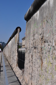 An ugly concrete wall, crumbling and with gaps.  Reinforcing bars poke through the concrete.