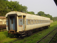 A railway carriage with 'SLEEPING CAR' painted on the side at the near end and '1ST' at the far end.