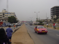 Looking along the ring road, busy main carriageway on the right, local traffic lane on the left, Dave walking up the reservation between.