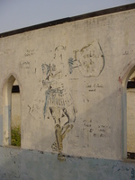 The remains of a mural of an angel on the wall of what remains of a chapel
