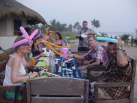 People sitting outside at a table with balloon animals.