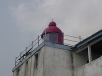 A lighthouse perched on top of a whitewashed fort.