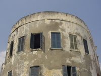 A curved buidling with many shuttered windows.