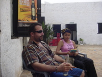 Dave and Marebec sitting in plastic chairs in the courtyard of a whitewashed fort.