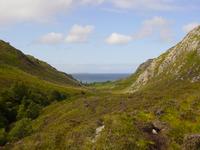 View down a narrow valley with the sea visible at the end