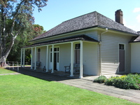 A small wooden house with a lawn.