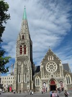 A grey and white stone cathedral with a spire.