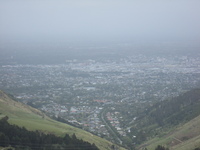 In the foreground green hills slope down to a city.