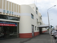 An Art Deco building with cars parked outside.