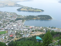 A town is seen from above.  It surrounds a lake and extends a peninsula out into the lake.