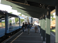A blue-painted train in a station.