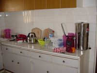 Picture of the kitchen, showing the cupboards and water filter