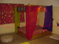Room with coloured lights and covered bed
