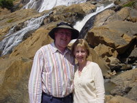 Parents standing in front of a rocky waterfall