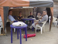 Indar, Amy, Mary, Charles (behind Pete) and Pete sitting at a table under a canopy