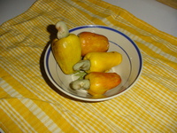 A bowl of long yellow fruit with kidney-shaped nuts sticking out of one end of each.