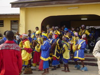 Group of dancers in blue and yellow entering through a gateway