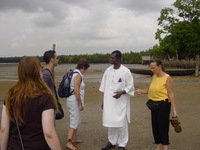 A small group of people meet a local man dressed in s shining white outfit