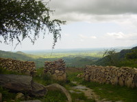 A gap in a dry stone wall, with a stone-paved path coming through