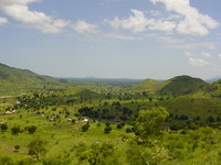 A valley with vegetation-covered hills on both sides, getting smaller in the distance