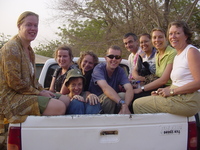 Lots of people sitting in the back of a pick-up truck