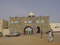 A gateway building with brightly-coloured patterns painted on it.