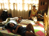 Tanya and Mavic lying on a bed, Marebec sitting on a chair.