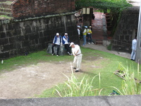 Golfers playing between old stone walls.