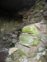 Wooden coffins piled up in a cave.